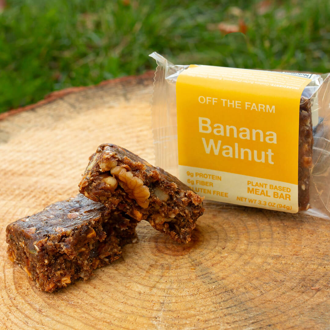 Banana Walnut meal bar with packaging on a wooden surface