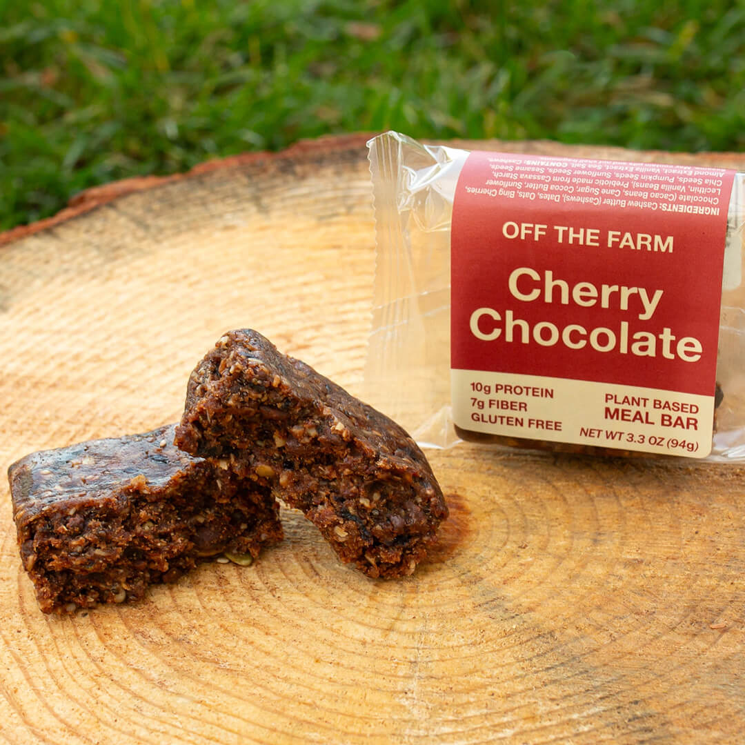 Cherry chocolate meal bar with packaging on a wooden surface