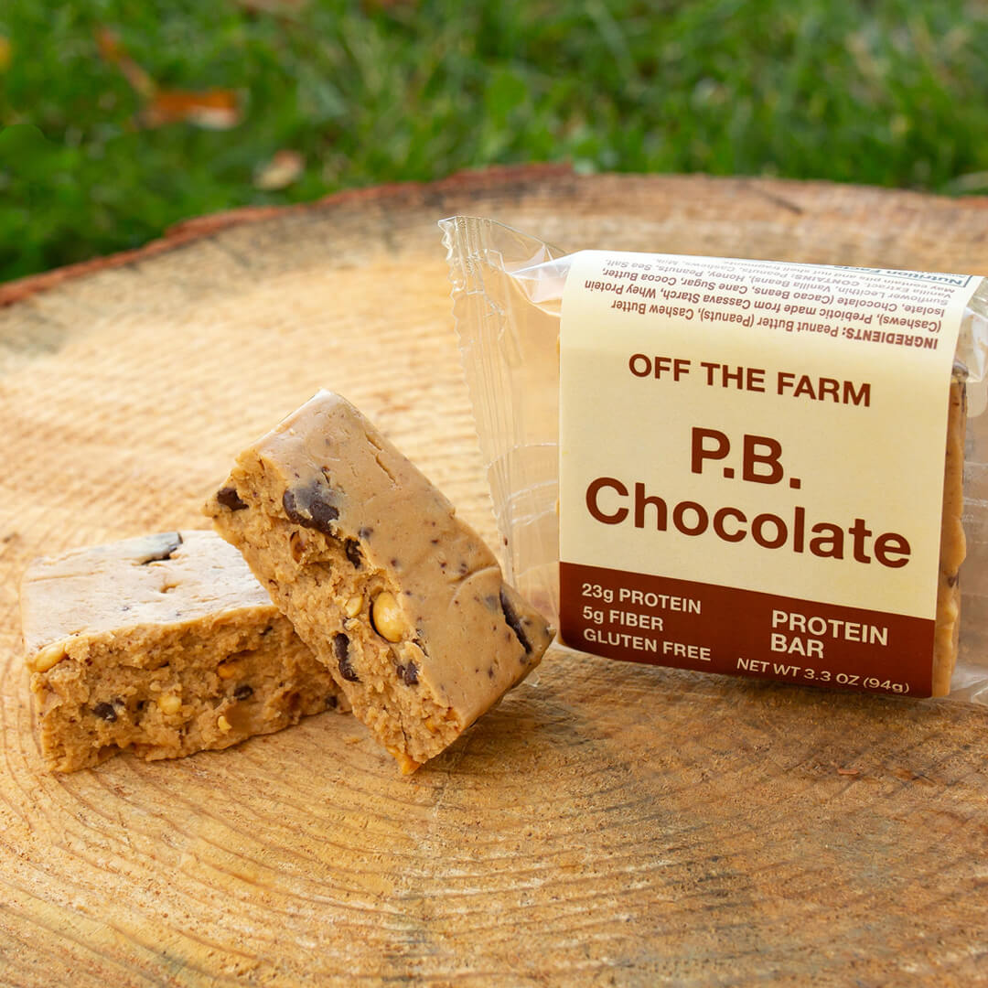 P.B. Chocolate protein bar with packaging on a wooden surface outdoors