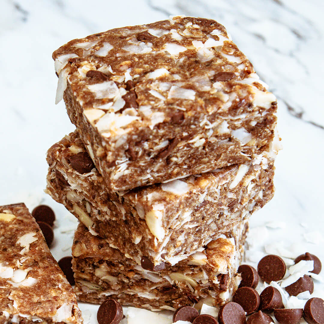 A stack of three cocoa coconut meal bars on a marble countertop