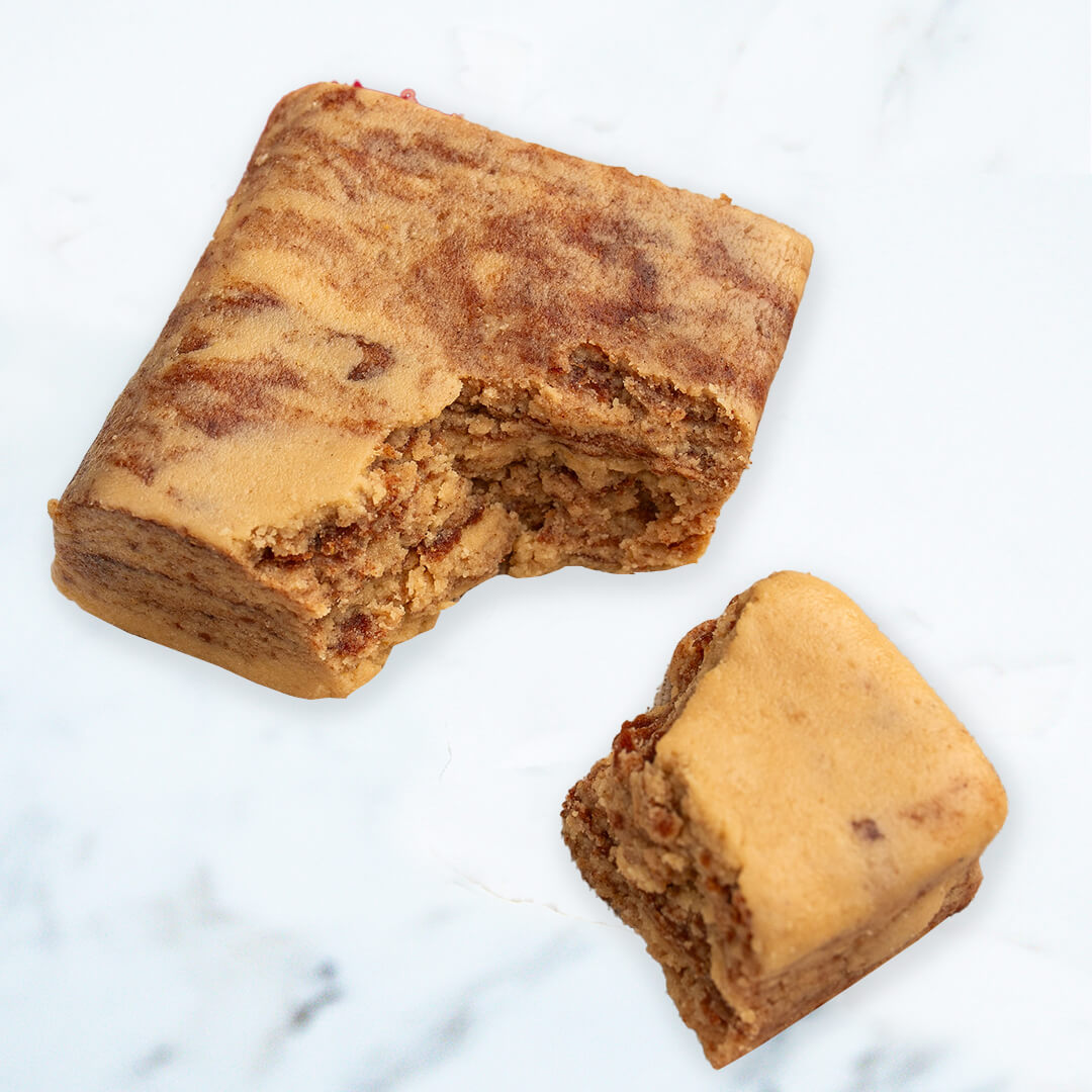 Two pieces of peanut butter & Jelly protein bar on a marble surface