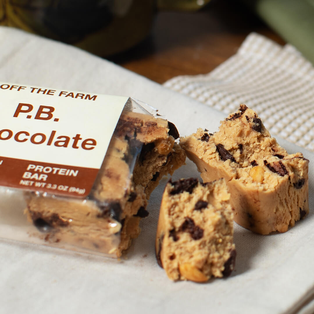 P.B Chocolate Protein bar on a white surface with 'Off the Farm' packaging.