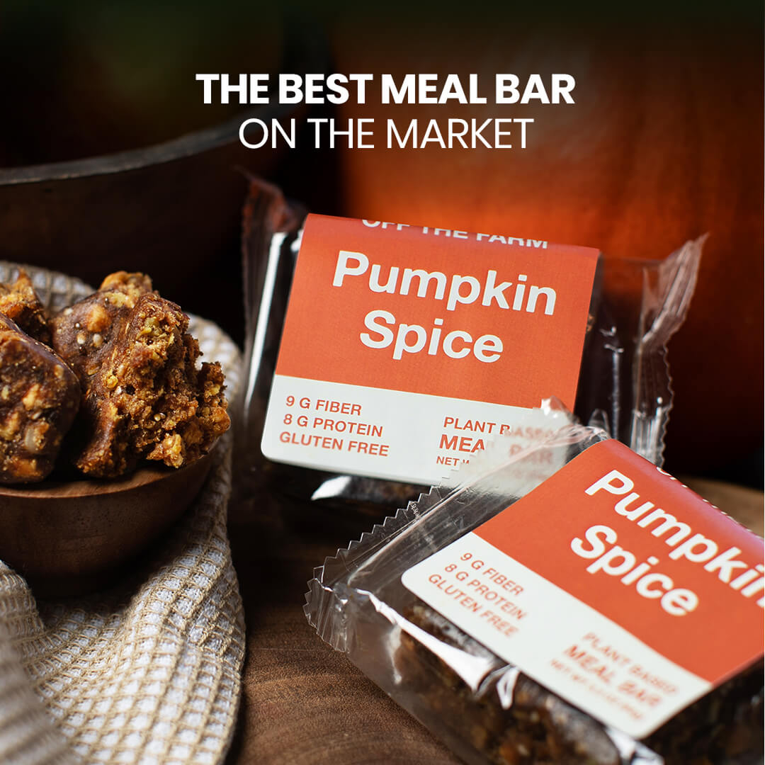 Pumpkin spice meal bars with a bowl of snacks on a wooden surface.