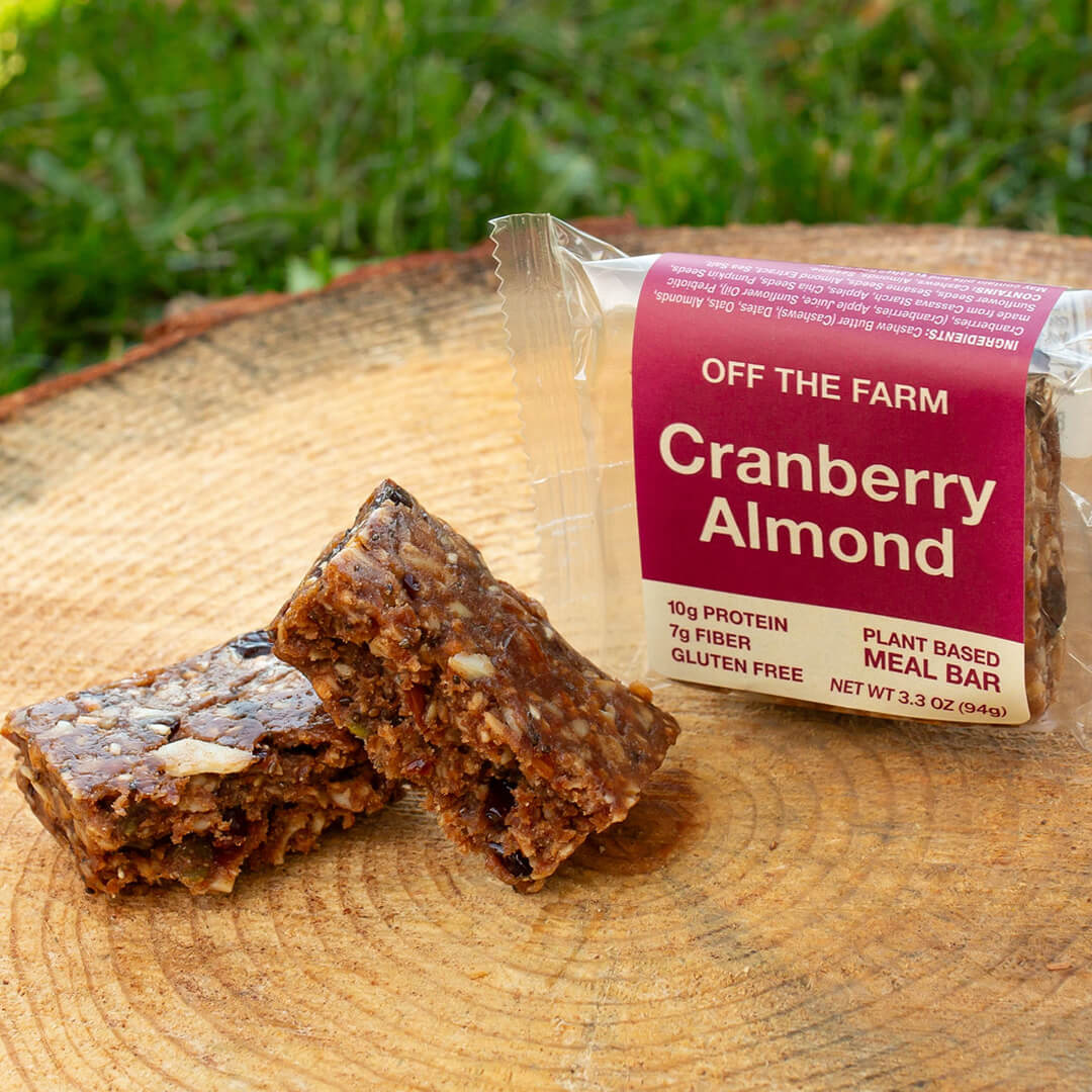 Cranberry Almond meal bar with packaging on a wooden surface outdoors