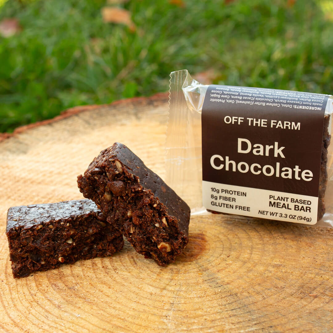Dark chocolate meal bar with packaging on a wooden surface