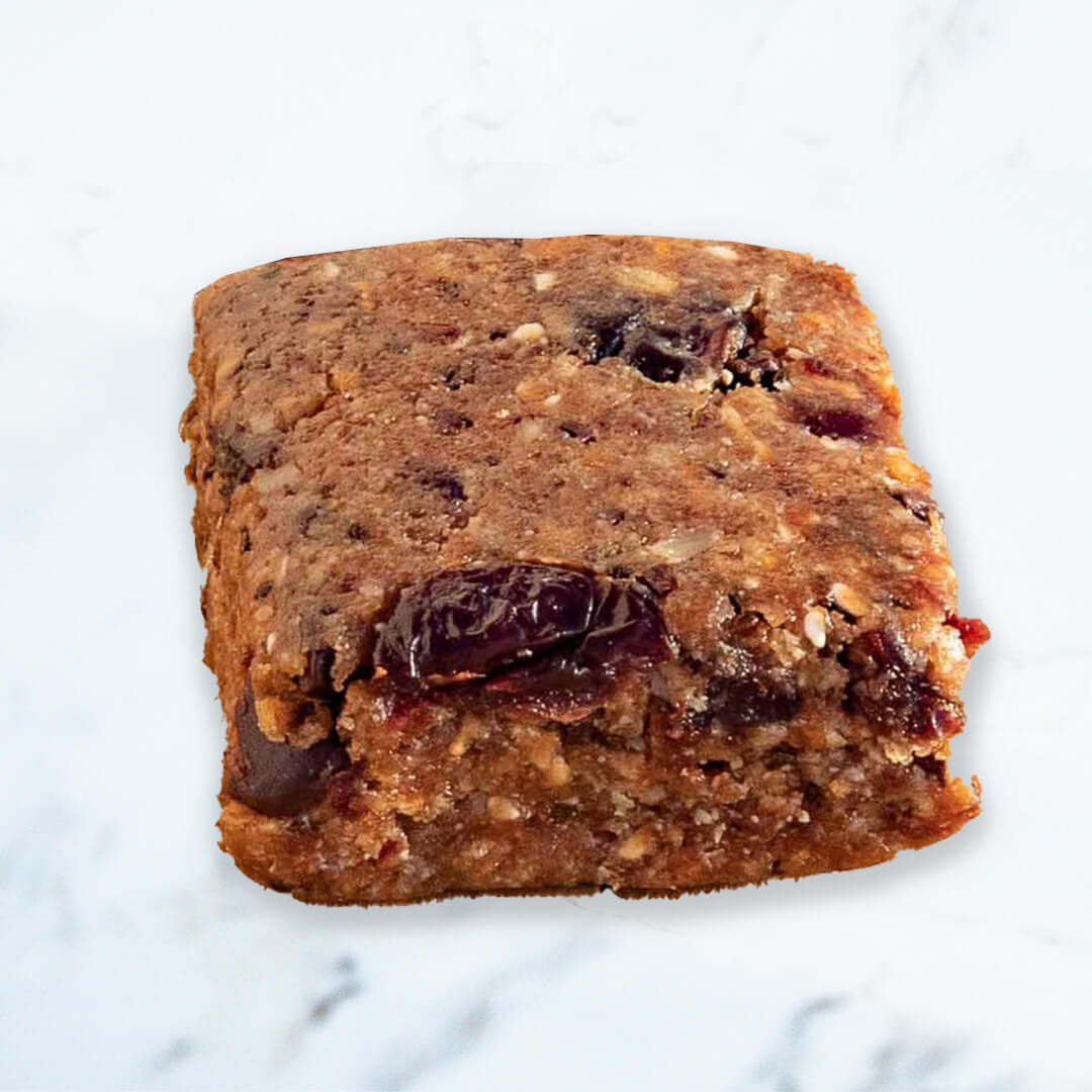 Off the farm cherry chocolate meal bar with dates on a marble surface