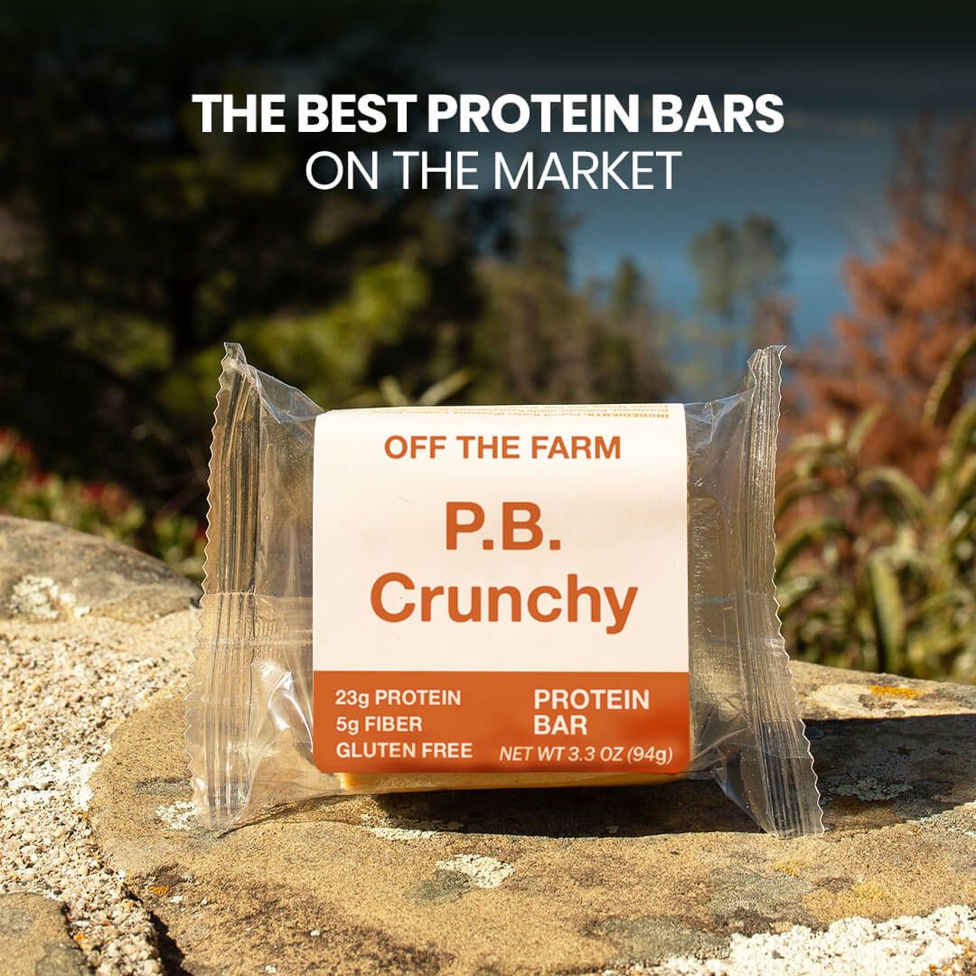 P.B. Crunchy protein bar packaging on a rock with nature in the background