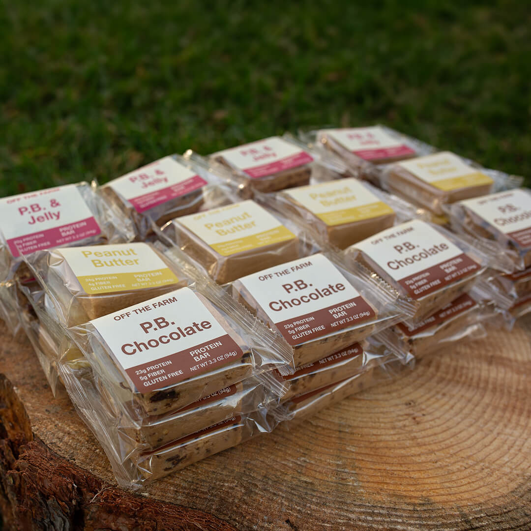 Assorted OFF THE FARM protein bars on a log