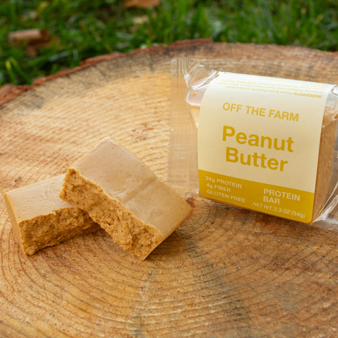 OFF THE FARM Peanut butter protein bar with packaging on a wooden surface
